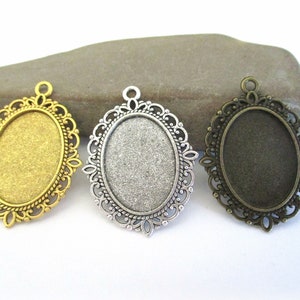 May include: Three oval-shaped metal pendant trays with ornate filigree designs. The trays are gold, silver, and bronze in colour.