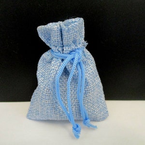 May include: A small light blue burlap drawstring bag with a white lining. The bag is tied shut with a blue cord.