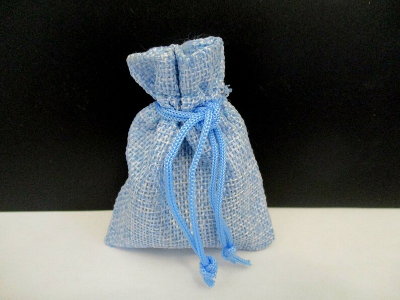 May include: A small light blue burlap drawstring bag with a white lining. The bag is tied shut with a blue cord.