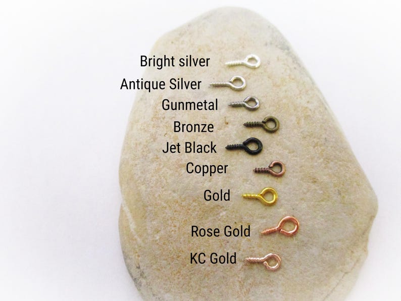 May include: A close-up of a rock with a row of eight different colored eyelet screws. The colors are bright silver, antique silver, gunmetal, bronze, jet black, copper, gold, rose gold, and KC gold.