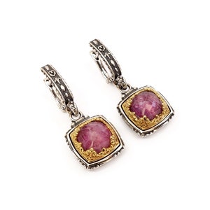 May include: A pair of silver hoop earrings with a pink gemstone pendant. The pendant is set in a gold frame with intricate details.