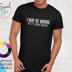 Puede incluir: Camiseta negra con el texto blanco "I MAY BE WRONG BUT IT'S HIGHLY UNLIKELY". La camiseta también presenta una rueda de colores y las palabras "VARIOUS COLOURS AVAILBLE". Es una prenda personalizada.