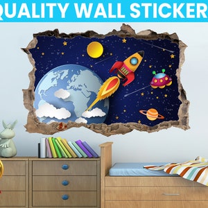 Puede incluir: Una pegatina de pared colorida con temática espacial que presenta un cohete, un planeta y un OVNI. La pegatina está diseñada para parecer que está rompiendo una pared, creando un efecto 3D. La pegatina es perfecta para la habitación de un niño o una sala de juegos.