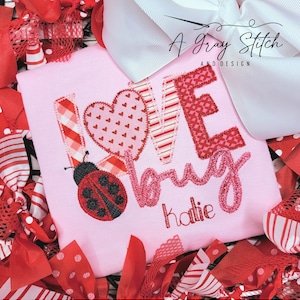 May include: Pink shirt with a red, white and pink applique that says "Love Bug" with a ladybug and the name "Katie" embroidered below.