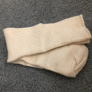 May include: A pair of off-white ribbed socks folded together. The socks are made of a soft, comfortable material.