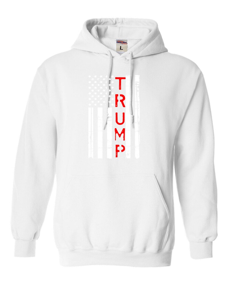 May include: White hooded sweatshirt with a red "TRUMP" printed vertically down the center of a white and gray American flag design.