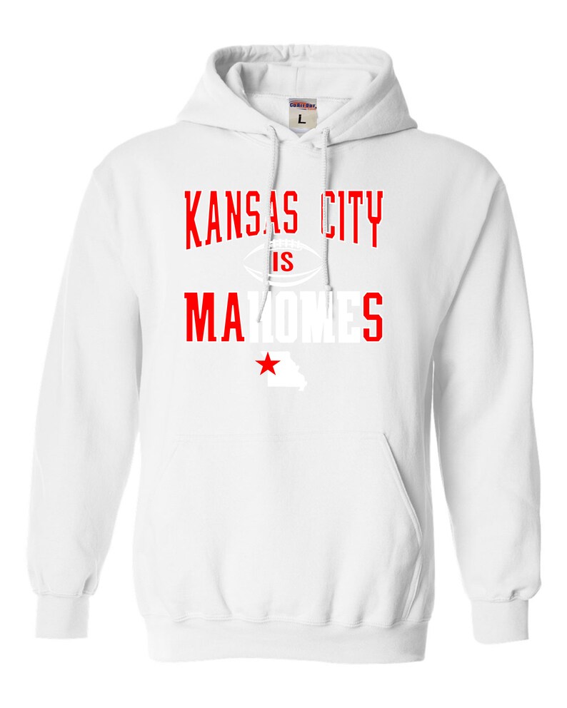 Puede incluir: Sudadera con capucha blanca con texto rojo que dice "Kansas City is Mahomes" con un gr&aacute;fico de f&uacute;tbol y una estrella roja sobre un contorno blanco del estado de Misuri.