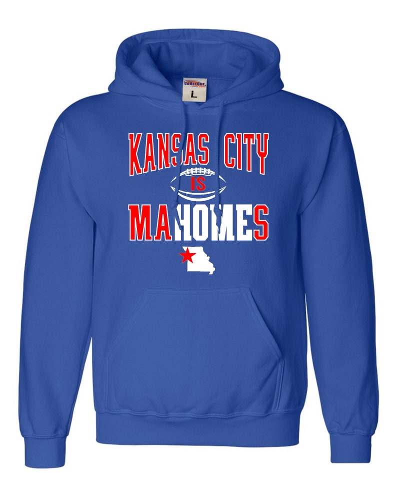 Puede incluir: Sudadera con capucha azul real con un gr&aacute;fico blanco que dice "Kansas City is Mahomes" con un bal&oacute;n de f&uacute;tbol y el estado de Misuri con una estrella roja.