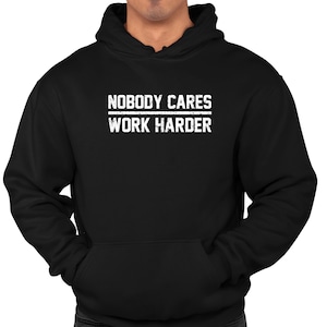 May include: Black hooded sweatshirt with white text that reads "Nobody Cares Work Harder".