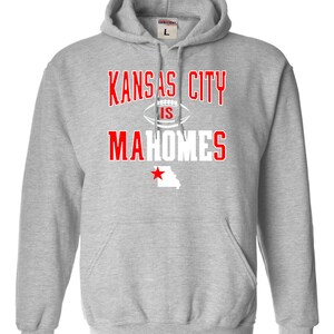 Puede incluir: Sudadera con capucha gris con el texto "Kansas City is Mahomes" en blanco con una estrella roja y el contorno del estado de Misuri.