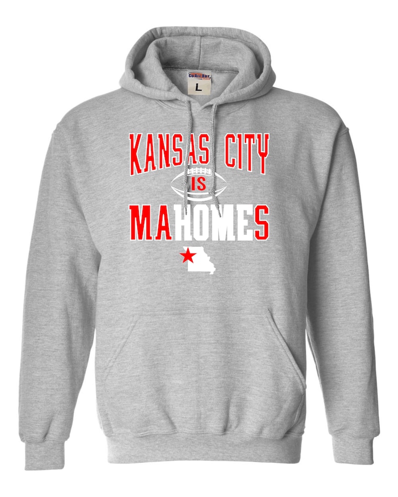 Puede incluir: Sudadera con capucha gris con el texto "Kansas City is Mahomes" en blanco con una estrella roja y el contorno del estado de Misuri.