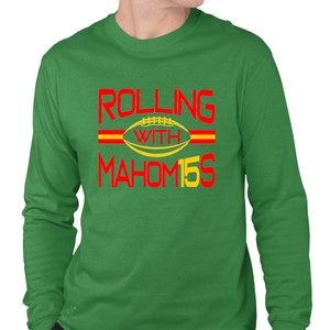 May include: Green long-sleeve t-shirt with red and yellow text that reads "Rolling with Mahomes 15" and a football graphic.