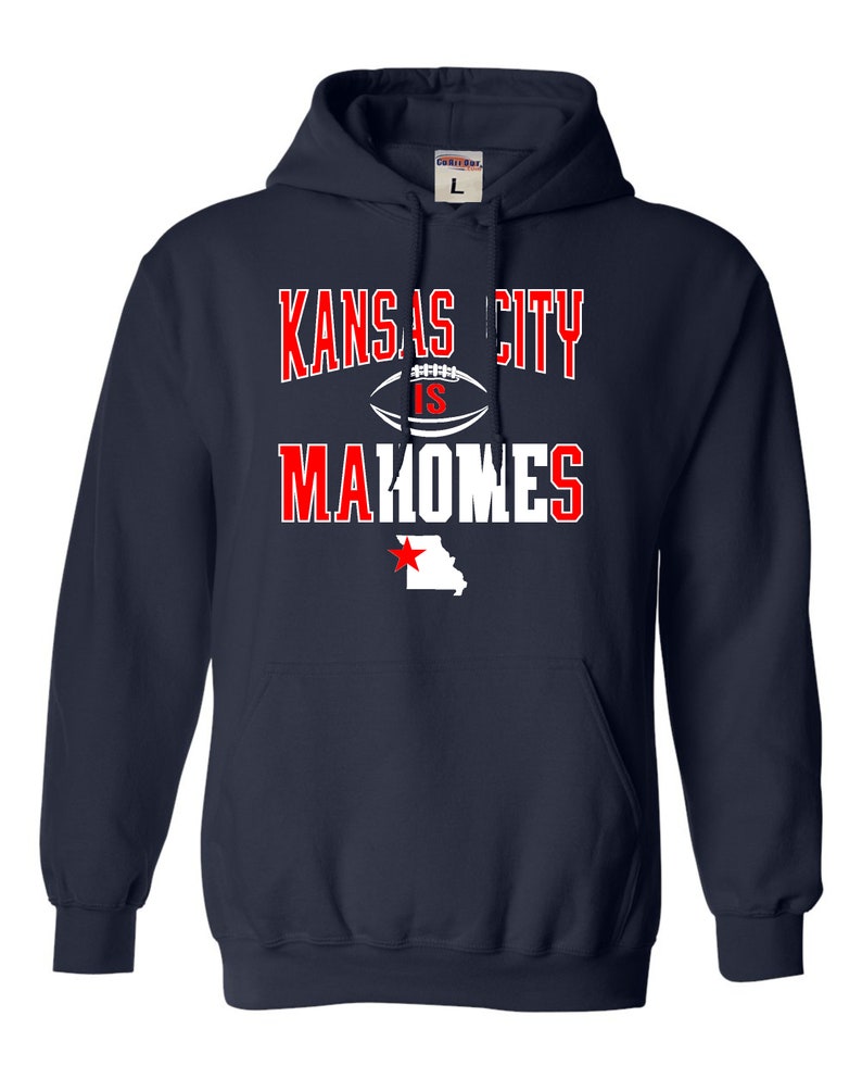 Puede incluir: Sudadera con capucha azul marino con texto blanco que dice "Kansas City is Mahomes" y un contorno blanco del estado de Misuri con una estrella roja.