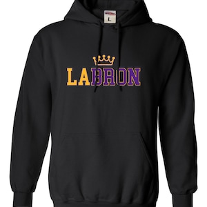 May include: Black hooded sweatshirt with a purple and yellow graphic that says "LEBRON" with a gold crown above the text.