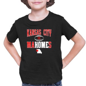 K&ouml;nnte beinhalten: Schwarzes T-Shirt mit wei&szlig;em Text, der "Kansas City is Mahomes" lautet, mit einer Football-Grafik und einem roten Stern &uuml;ber einem wei&szlig;en Umriss des Bundesstaates Missouri.