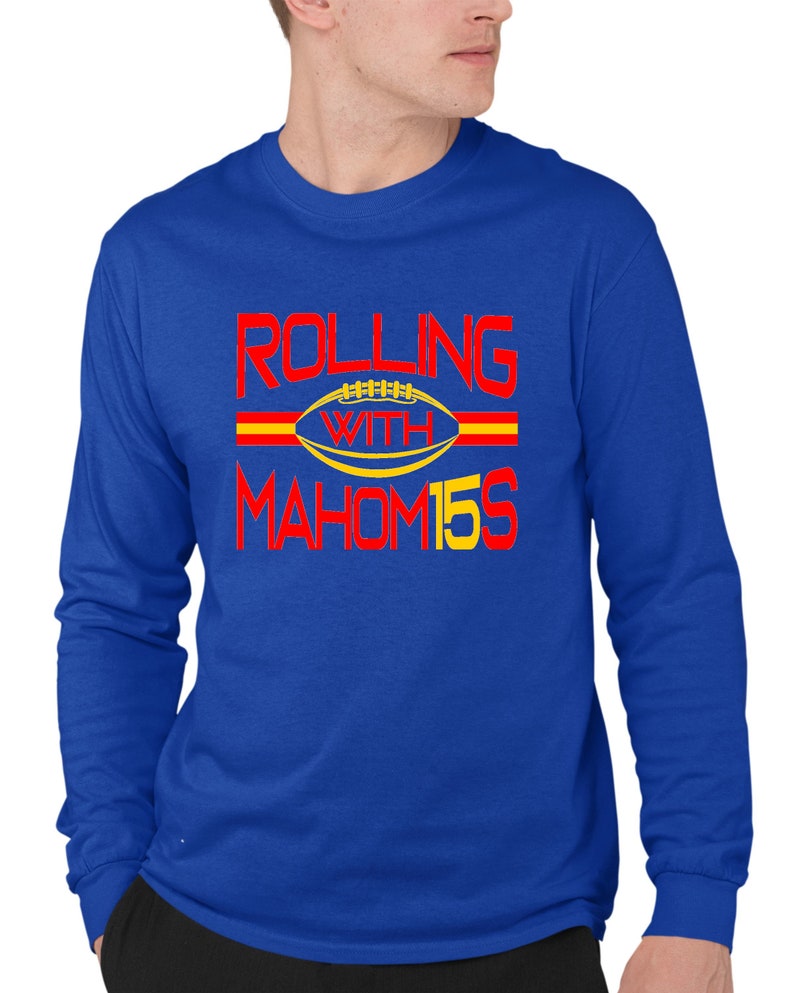 May include: A royal blue long-sleeved t-shirt with the text "Rolling with Mahomes 15" in red and yellow.