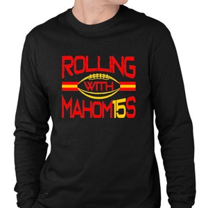 May include: Black long-sleeve sweatshirt with red and yellow text that reads "Rolling with Mahomes 15". A football graphic is included in the text.