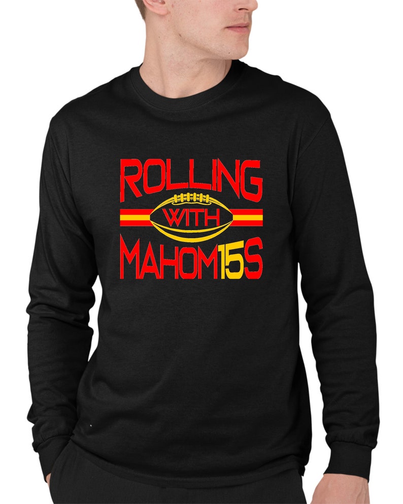 May include: Black long-sleeve sweatshirt with red and yellow text that reads "Rolling with Mahomes 15". A football graphic is included in the text.