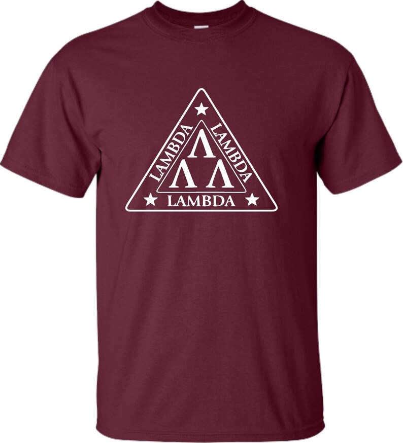 May include: A maroon t-shirt featuring a white triangular design. The triangle has a white star at each point and the text "Lambda" written on each side. Inside the triangle are three white "A"s stacked on top of each other.