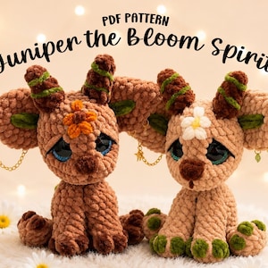 May include: Two crocheted plush creatures titled Juniper the Bloom Spirit, featuring tan and brown yarn, large dark eyes, textured horns with green stripes, and floral accents. Each figure has large ears adorned with small gold chains and charms.