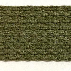 May include: Close-up of a green woven fabric ribbon. The ribbon has a textured, diamond-shaped pattern.