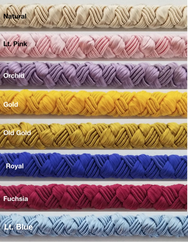May include: A close-up of eight different colors of braided cord. The colors are natural, light pink, orchid, gold, old gold, royal blue, fuchsia, and light blue.