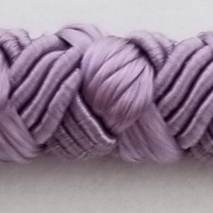 May include: A close-up of a lavender braided trim. The trim is made of a soft, silky fabric and has a delicate, intricate design.