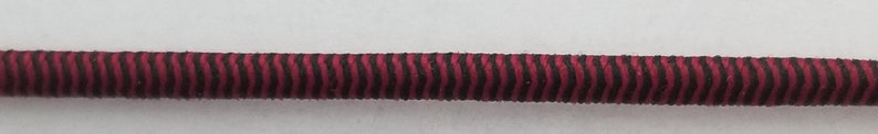 May include: A close-up of a red and black striped elastic cord.