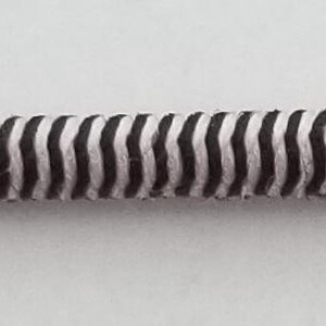 May include: A black and white striped elastic cord, perfect for crafting projects.