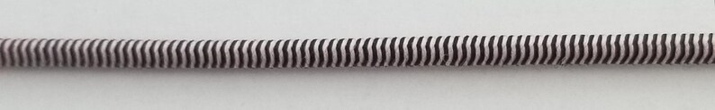 May include: A black and white striped elastic cord, perfect for crafting projects.