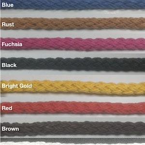 May include: A collection of braided cotton cords in various colors, including light pink, jade, blue, rust, fuchsia, black, bright gold, red, brown, white, and light blue aqua. Each cord is a different color.