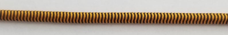 May include: A black and yellow striped elastic cord.