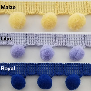 Op de afbeelding: Drie rijen trim met pompoenen. De bovenste rij is geel, de middelste rij is lila en de onderste rij is koninklijkblauw. De trim is een geweven gaas met een gegolfde rand.