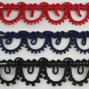 May include: Three samples of trim with scalloped edges. The trim is red, navy blue, and black.