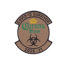 May include: A tan embroidered patch with a black border. The patch is shaped like a circle with a crown on top. The text "COVID-19 SURVIVOR" is written around the circle. Inside the circle is the text "Corona Virus" with a biohazard symbol underneath. The text "2020-21" is written below the symbol.