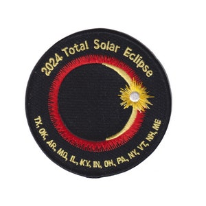 May include: A black embroidered patch with gold and red stitching depicting a crescent moon with a sun behind it. The text "2024 Total Solar Eclipse" is written in a circle around the moon and sun. The text "TX, OK, AR, MO, IL, KY, IN, OH, PA, NY, VT, NH, ME" is written in a circle around the moon and sun.