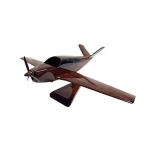May include: A handcrafted wooden airplane model with a dark brown finish. The model features a propeller, wings, and a sleek fuselage. The airplane is a detailed replica, perfect for display.