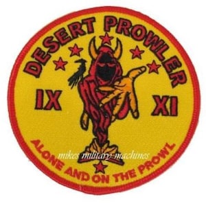 May include: A yellow and red circular patch with the text "Desert Prowler IX XI Alone and on the Prowl" and a red devil figure with horns and a black bird.