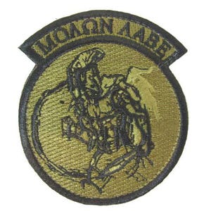 May include: A green and black embroidered patch with the words "HONORABLE" in a circle around a black and green image of a warrior.