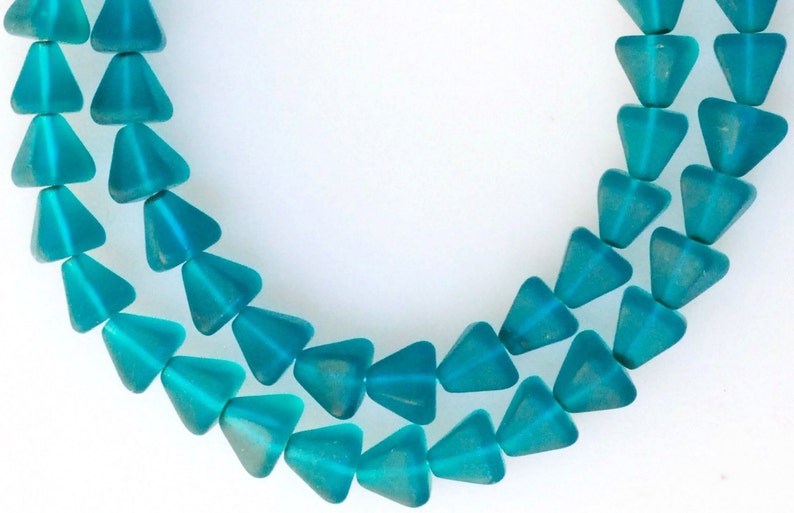 May include: A strand of teal blue glass beads in a triangular shape.