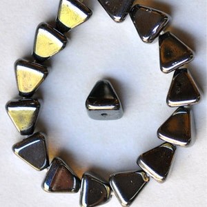 May include: A strand of black triangular glass beads with a single bead separated from the strand. The beads have a shiny, metallic finish.