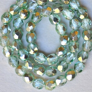 May include: A strand of light green faceted glass beads with a silver metallic finish.