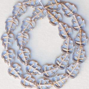 May include: A strand of light blue glass beads in the shape of leaves with gold accents.