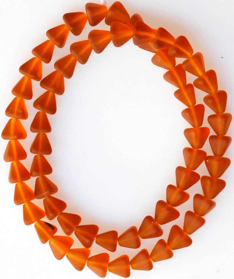 May include: A strand of orange glass beads in a triangle shape.
