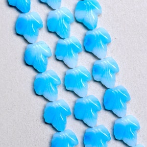 Puede incluir: Una colecci&oacute;n de hojas de vidrio azul claro con un dise&ntilde;o de remolino blanco. Las hojas est&aacute;n dispuestas en un patr&oacute;n diagonal sobre un fondo blanco.
