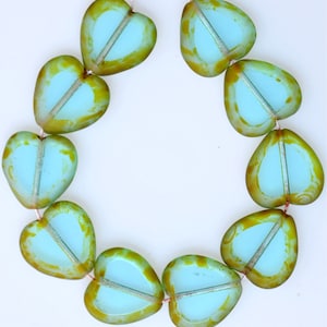 May include: A strand of light blue heart-shaped glass beads with a green and gold marbled pattern.