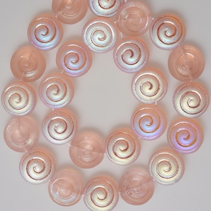 May include: A strand of pink glass beads with a swirl design. The beads are iridescent and have a subtle shimmer.