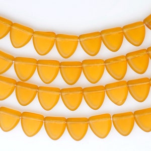 Puede incluir: Una hebra de cuentas de vidrio naranja en forma de lágrima. Las cuentas son translúcidas y tienen un acabado brillante.