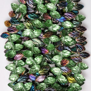 May include: A strand of green glass beads with iridescent accents. The beads are shaped like leaves and have a textured surface.