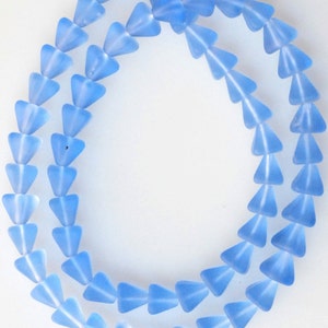May include: A strand of light blue glass beads in a triangle shape.